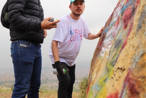 Guía de Bogotá Colors enseña a invitado a recorrido a pintar un mural