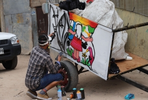 artista realiza grafiti sobre carreta