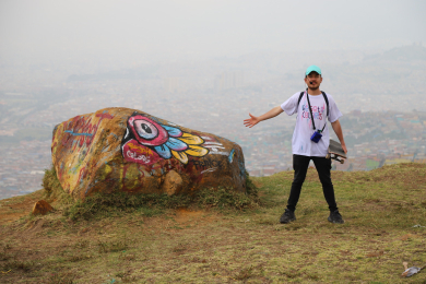 Grafiti tour en Ciudad Bolívar - Hombre con piedra pintada y vista de Bogotá