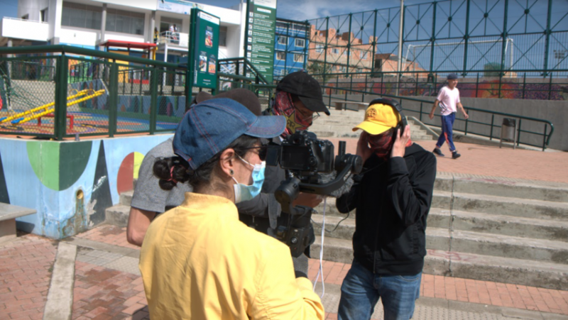 Dos hombres con cámara y mujer observando