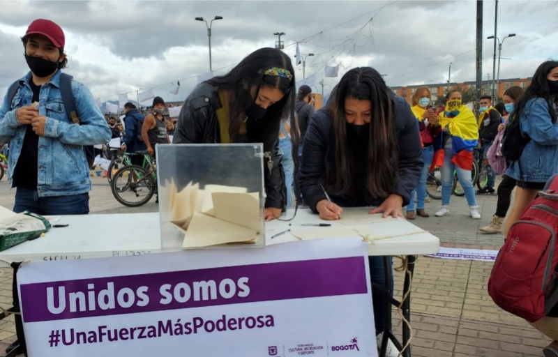 Dos jóvenes escribiendo en una hoja