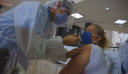 Enfermera aplicando vacuna a mujer